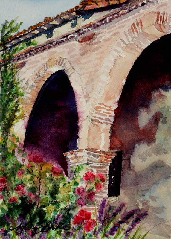 Painted during the San Juan Capistrano Mission tour this watercolor features stone arches and red flowers by Mary Benke