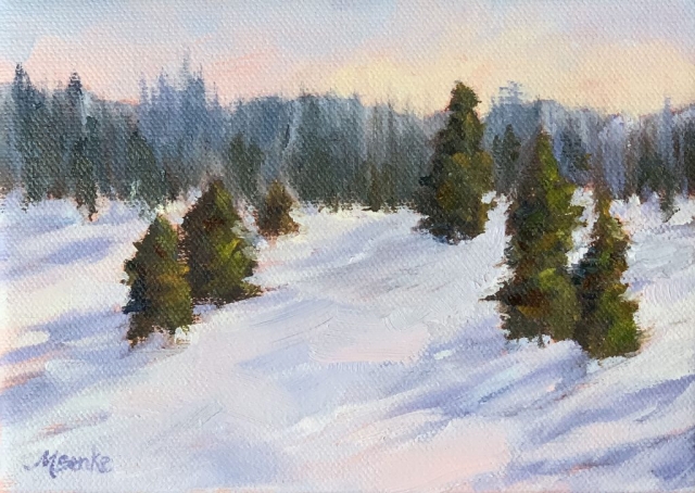 A warm glow lights the sky in this peaceful snow scene featuring pines and their dramatic shadows by Mary Benke